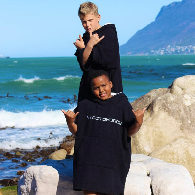 Two kids wearing long-sleeved  Carbon Black Octohoodies at a tidal pool