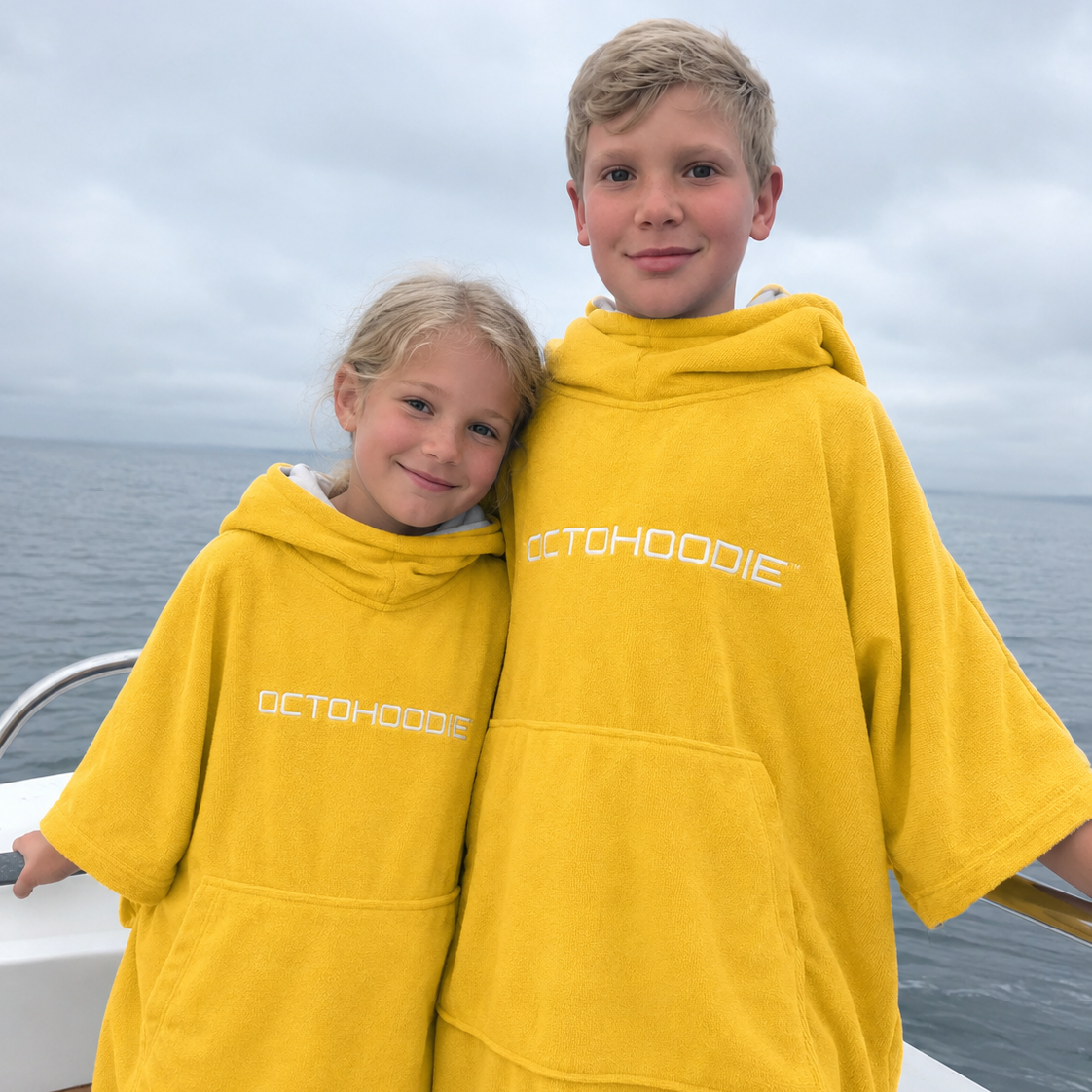 Brother and sister in yellow long-sleeved Octohoodie on a boat