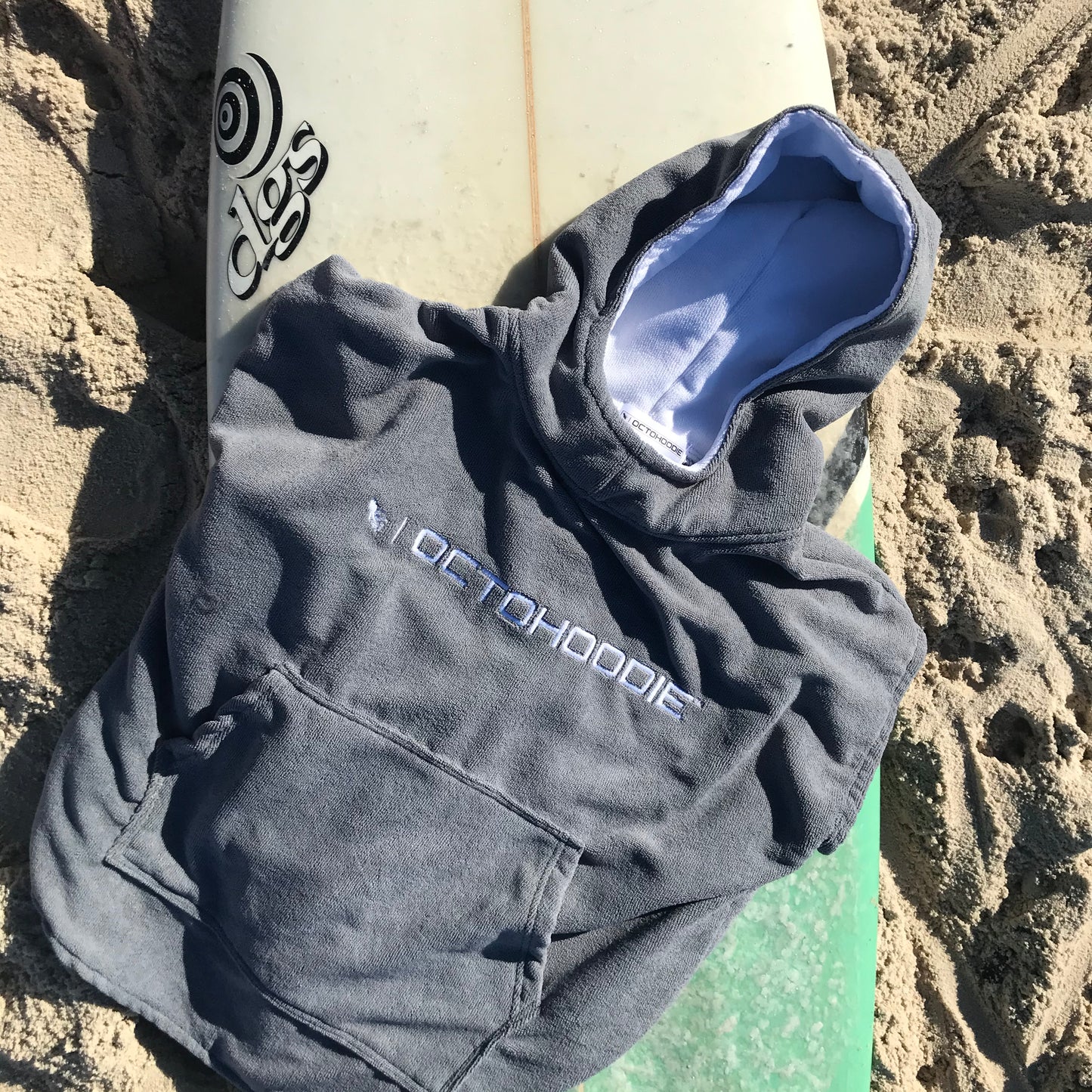 Octohoodie Kids short-sleeve on a surf board at the beach