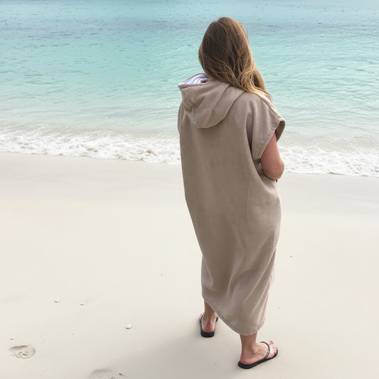 Woman in a beige Octohoodie, back view at beach in Cape Town.